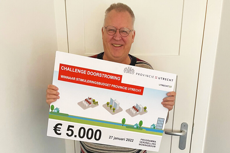 Een trotse Eric met de cheque van 5.000 euro. Met onze inzending – met als titel ‘Effecten van doorstroming meetbaar’ – hebben we het stimuleringsbudget van € 5.000 gewonnen!